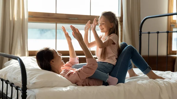 Happy mommy and kid daughter playing patty cake in bedroom — Stock Photo, Image