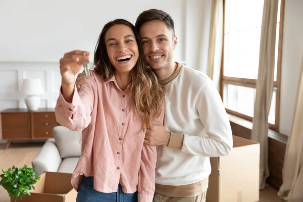 Casal feliz segurando a chave para a nova casa no dia em movimento — Fotografia de Stock