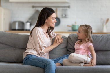 Mutlu anne ve tatlı çocuk kanepede rahatça konuşmanın keyfini çıkarın.