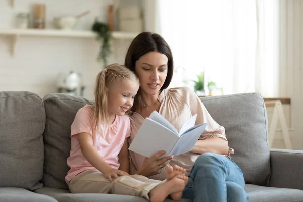 Mladá maminka čtení kniha výuka inteligentní školka dítě dcera — Stock fotografie