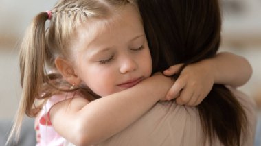 Minnettar küçük kız şirin yüz sevgi dolu koruyucu anneyi kucakla.