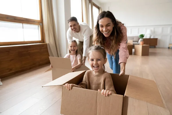 Parents heureux jouant avec les petits enfants chevauchant dans la boîte — Photo