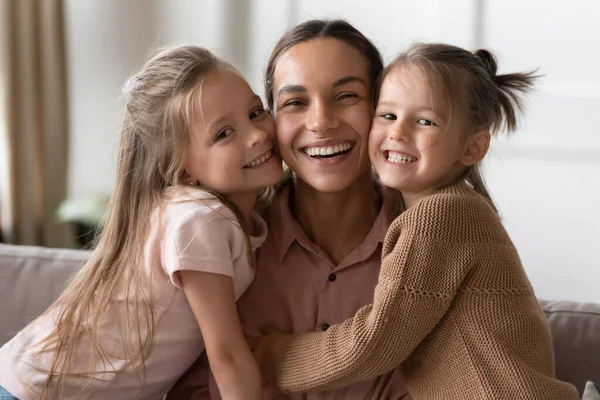 Happy mother and children daughters embracing looking at camera — Stock Photo, Image