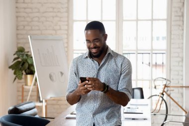 Mutlu karışık ırk genç şirket çalışanı mesaj atıyor..