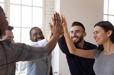 Coşkulu çok ırklı genç iş adamları beşlik çakıyor.