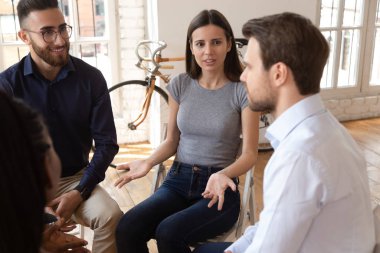 Çemberdeki sandalyelerde oturan çok ırklı iş adamları.