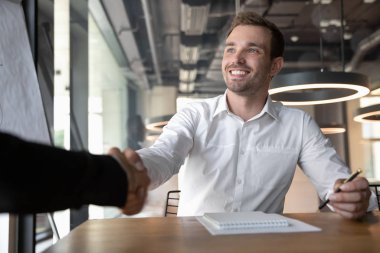 Gülümseyen beyaz iş adamının elini sıkın.