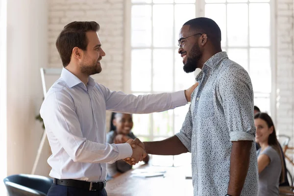 Confiado director de la empresa estrechando la mano con el empleado afroamericano feliz . — Foto de Stock