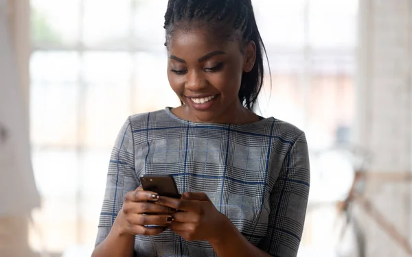 Sourire jeune femme d'affaires afro-américaine tenant smartphone . — Photo