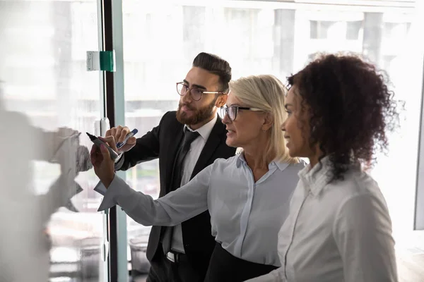 Multiraciale zakenmensen schrijven aan boord brainstorming in het kantoor — Stockfoto