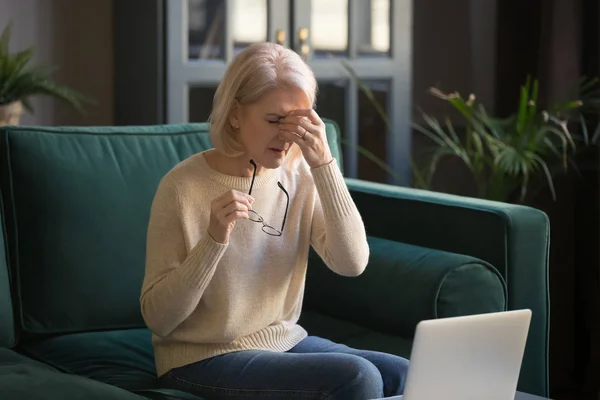 Alte Frau nimmt Brille ab und leidet unter trockenen Augen — Stockfoto