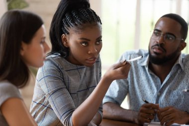 Konsantre olmuş Afro-Amerikan kadın yönetici kalemi işçiye doğrultuyor..