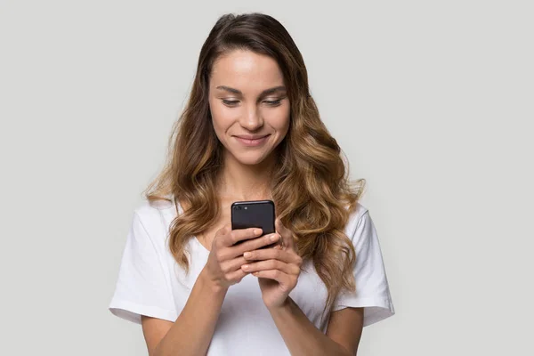 Nöjd ung kvinna tittar på skärmen, med hjälp av mobilappar — Stockfoto