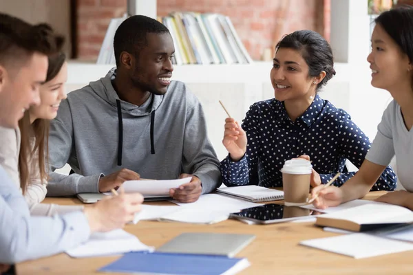 Felices amigos universitarios diversos escuchando a su compañera de equipo india . — Foto de Stock