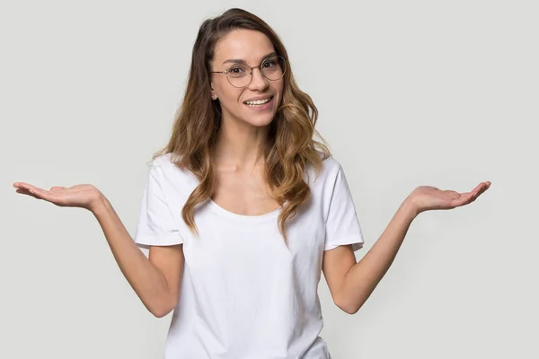 Verwirrte junge Frau mit Brille zuckt mit den Schultern — Stockfoto