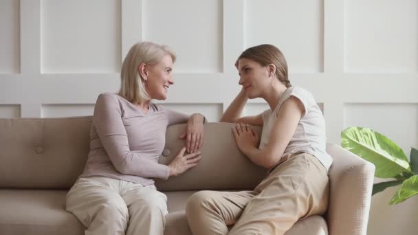 Feliz hija adulta y madre madura hablando chismes en casa — Vídeos de Stock