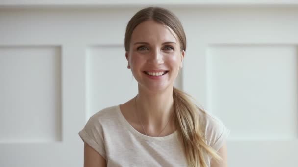 Sonriente joven mujer hablando video llamadas en línea mirando a la cámara — Vídeo de stock