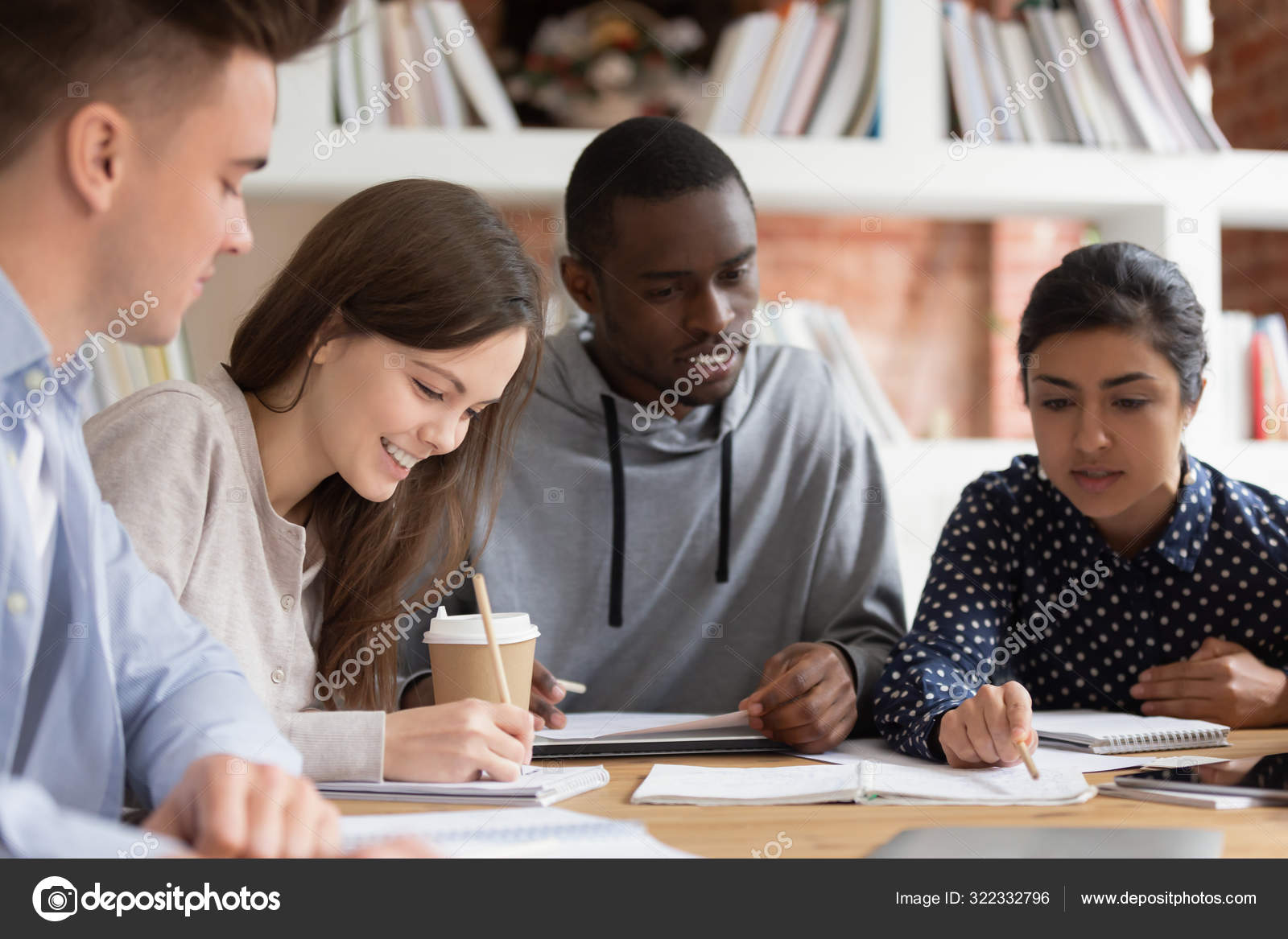 Grupo de estudiantes que trabajan juntos en el ordenador portátil en la