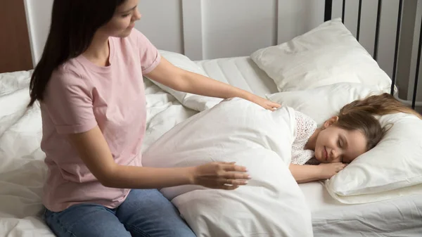 Joven mamá caricia hija pequeña la puso a dormir — Foto de Stock