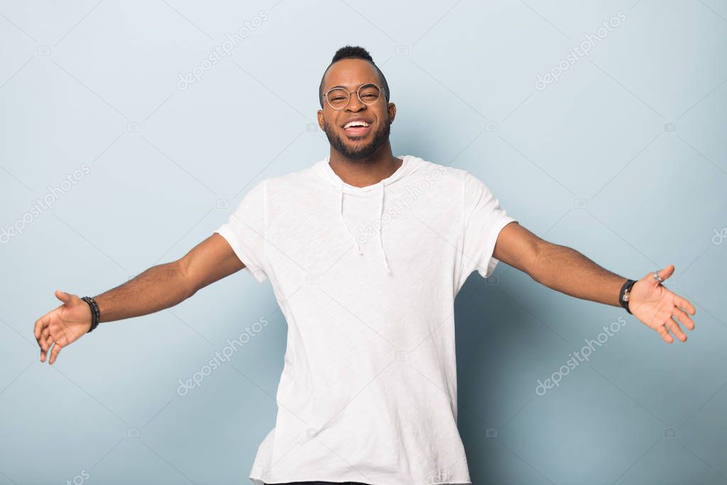 Happy friendly African American man raising hands, offering hugs