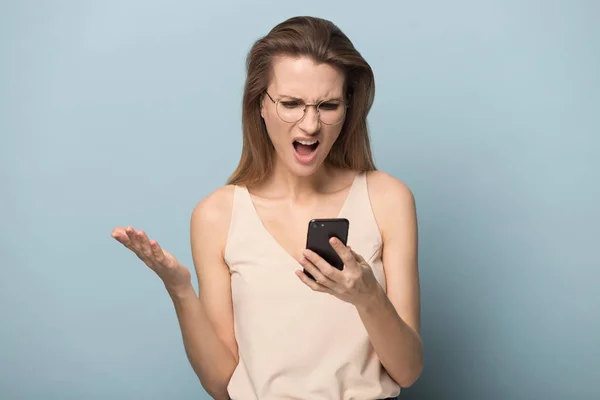 Unhappy angry woman using phone, reading bad news — Stock Photo, Image