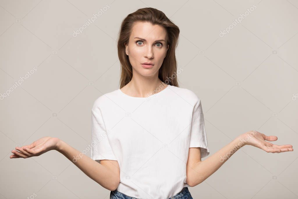 Unsure woman shrugging shoulders, feeling confused, looking at camera
