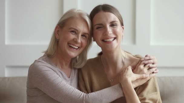 Leende mogen kärleksfull mamma omfamnar ung vuxen dotter, porträtt — Stockvideo