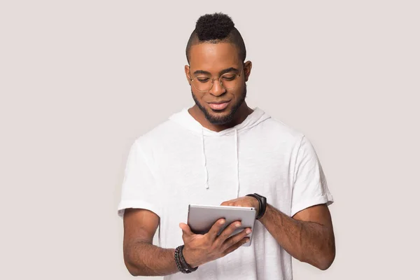 Homem afro-americano positivo usando computador tablet, olhando para a tela — Fotografia de Stock
