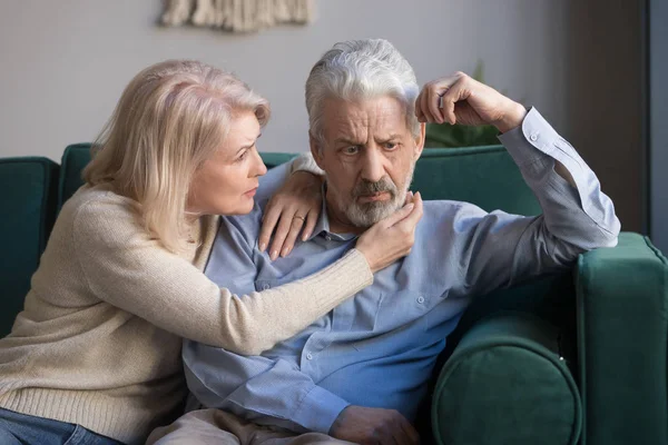Vrouw van middelbare leeftijd troostende overstuur grijsharige man — Stockfoto
