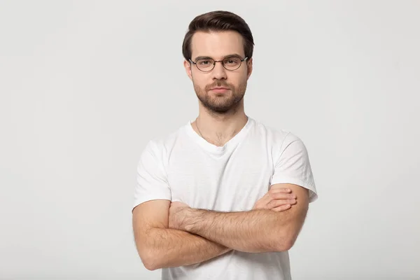 Serious millennial man in glasses posing with arms crossed — Stock Photo, Image