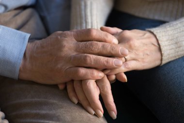 Yaşlı çiftin el ele tutuşurken ki görüntüsünü kapat.