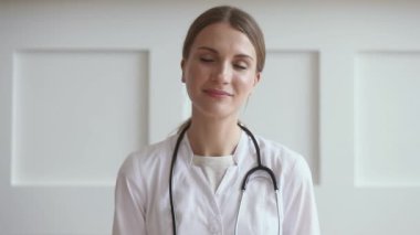 Genç kadın doktor görüntülü konuşma ile hastaya internet üzerinden danışıyor