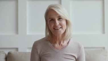 Yaşlı kadın Skype 'ta video görüşmesi yapıyor. Web kamerasıyla konuşuyor.