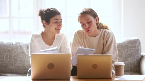 Två glada olika flickor studenter vänner studerar tillsammans hemma — Stockvideo