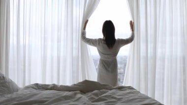 Mutlu kadın yataktan kalk, pencere perdesini aç.