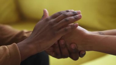Afrikalı bir kadının elini nazikçe okşayan zenci bir arkadaş.