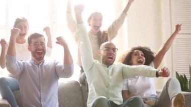 Aşırı neşeli çok kültürlü arkadaşlar grup futbol hayranları televizyon maçı izliyor.