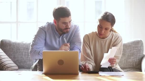 Vážné tisíciletý pár počítání domácích účtů doma s notebookem — Stock video