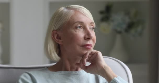 Feliz hermosa mujer mayor mirando a la cámara en casa — Vídeos de Stock