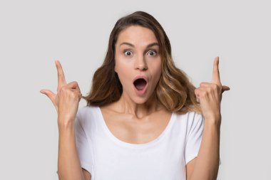 Heyecanlı genç bir kadın, ağzı açık, parmağını havaya kaldırıyor.