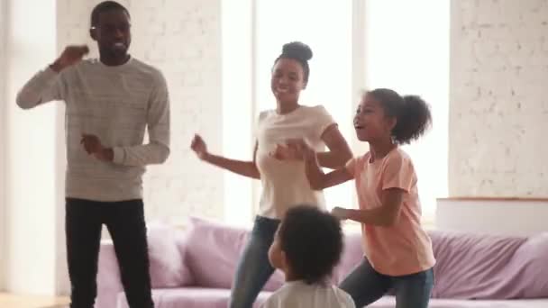 Gelukkige Afrikaanse ouders en leuke grappige kinderen dansen thuis — Stockvideo