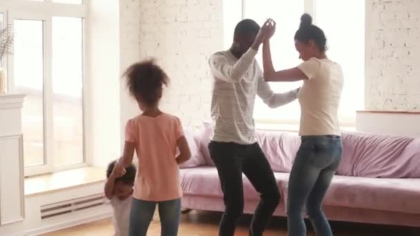 Счастливые африканские американские родители и дети танцуют дома — стоковое видео
