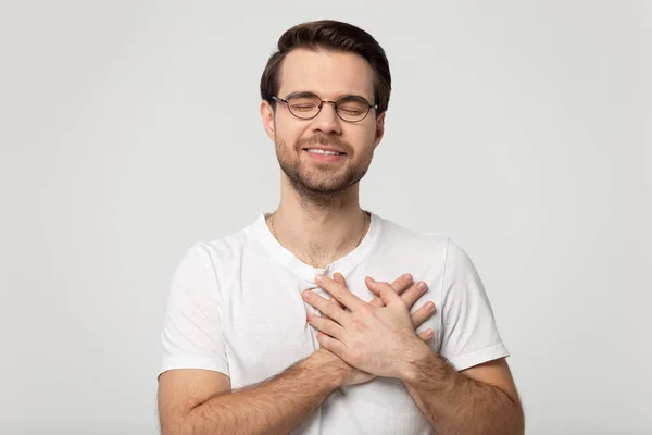 Grateful man in glasses feel thankful keeping hands on chest — Stock Photo, Image