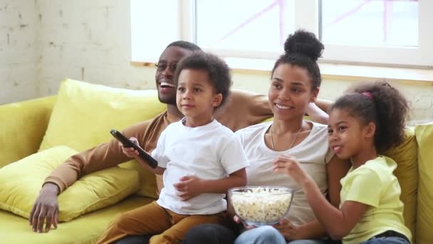 Glad afrikansk familj mamma pappa och barn tittar på tv — Stockvideo