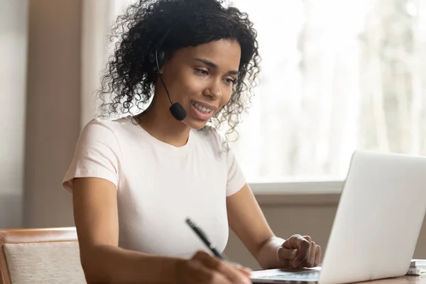 Mujer afroamericana en auriculares ver webinar en el ordenador portátil — Foto de Stock