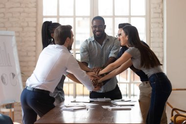Çok mutlu, çoklu etnik çeşitlilikte genç takım arkadaşları ofiste çalışanların birliğini kutluyor..