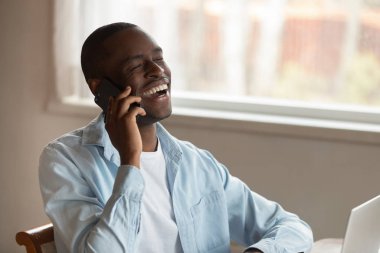 Mutlu çift ırklı adam cep telefonuyla gülüyor.