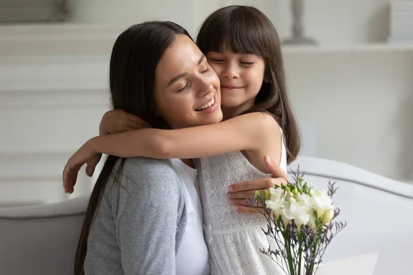 Madre cariñosa abrazo hija gracias por flores en el cumpleaños — Foto de Stock