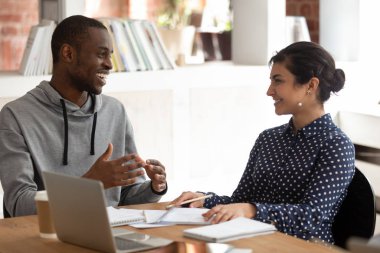 Neşeli siyahi adam, Hintli kızla proje fikirlerini tartışıyor..