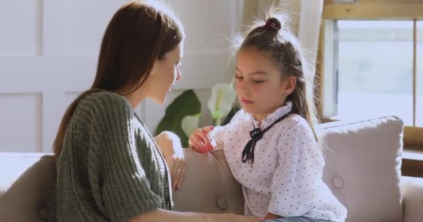 La mamma premurosa che parla con la figlia del bambino della scuola si siede sul divano — Video Stock